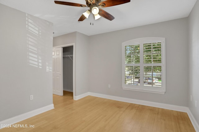 unfurnished bedroom featuring light hardwood / wood-style floors, a closet, and ceiling fan