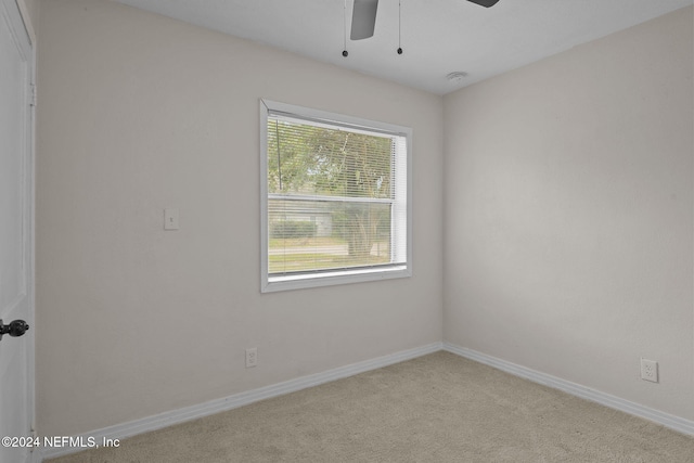 empty room featuring light colored carpet and ceiling fan