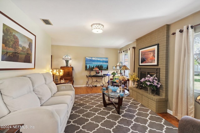 living room featuring dark hardwood / wood-style flooring and a brick fireplace