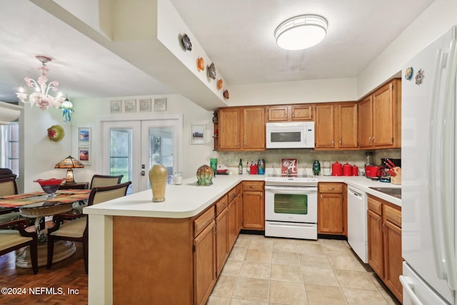 kitchen featuring kitchen peninsula, french doors, tasteful backsplash, white appliances, and decorative light fixtures