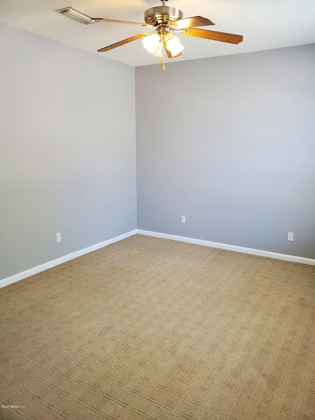 spare room with ceiling fan and light carpet