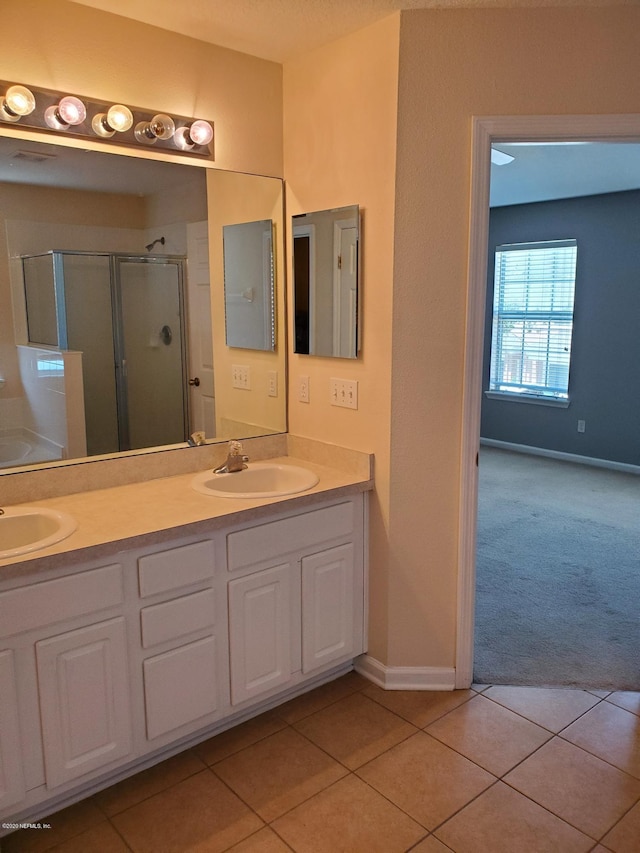 bathroom featuring tile patterned flooring, vanity, and a shower with door