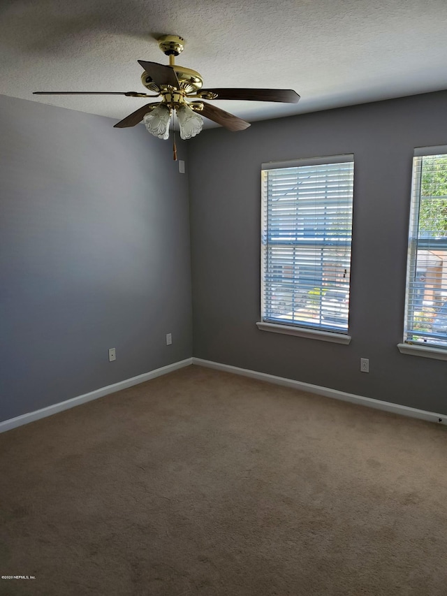 carpeted spare room with a textured ceiling and ceiling fan