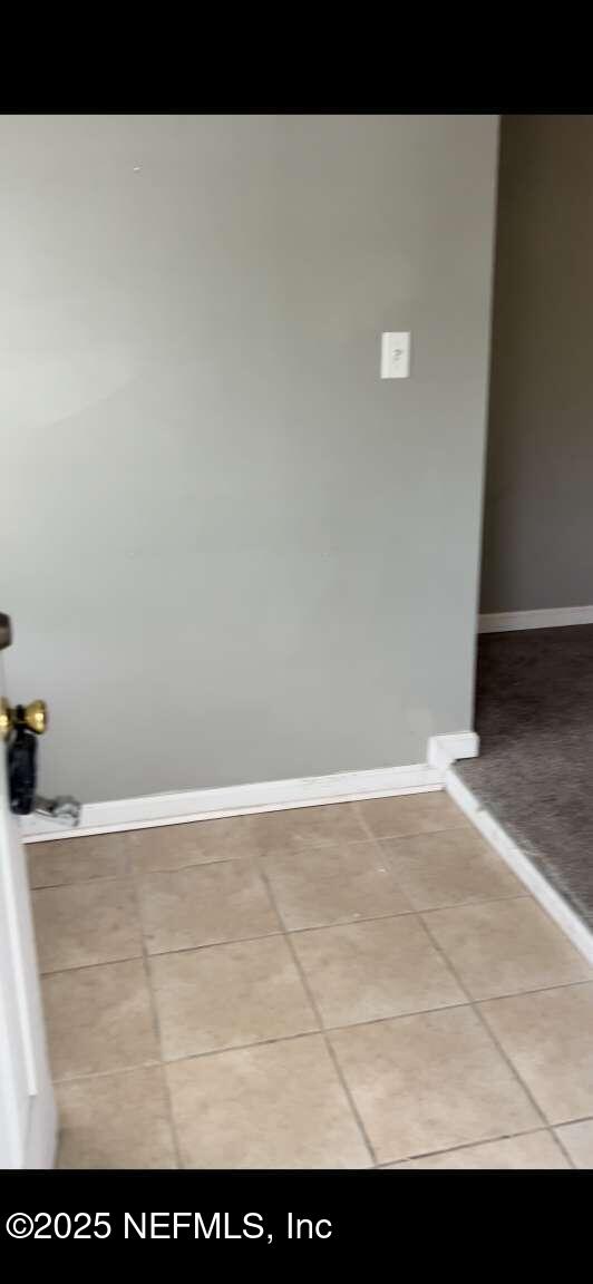 interior space featuring tile patterned flooring and baseboards