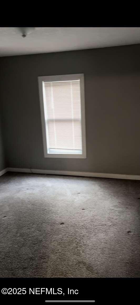 unfurnished room featuring baseboards and carpet flooring