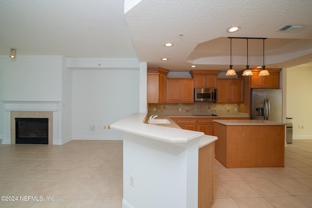 kitchen with sink, stainless steel appliances, kitchen peninsula, a textured ceiling, and decorative backsplash