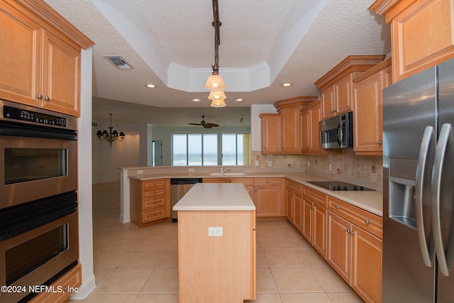 kitchen with a center island, stainless steel appliances, a raised ceiling, crown molding, and ceiling fan with notable chandelier