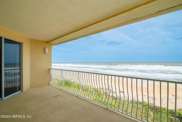 balcony featuring a water view and a view of the beach