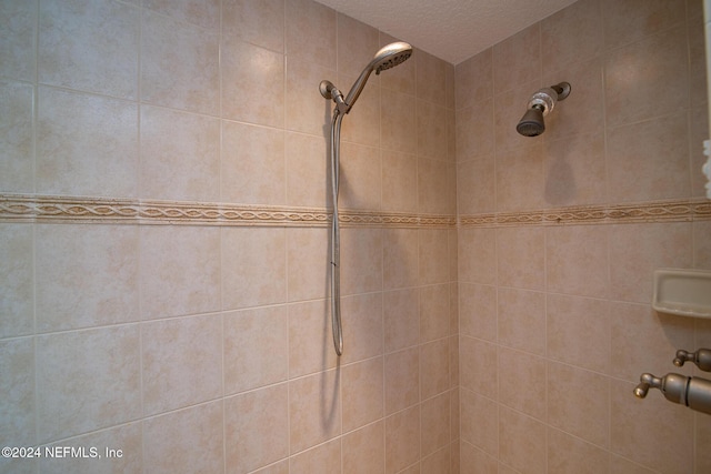 bathroom featuring a textured ceiling and tiled shower