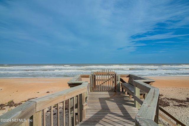 view of property's community featuring a water view and a beach view