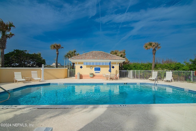 view of swimming pool featuring a patio area and an outdoor structure