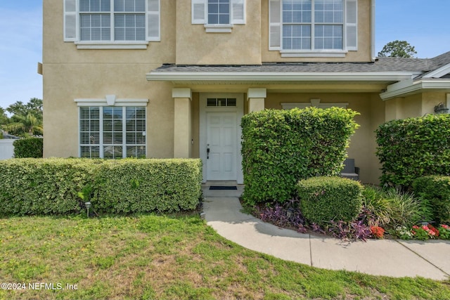 entrance to property featuring a yard