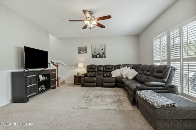 living room with a textured ceiling, carpet floors, ceiling fan, and a healthy amount of sunlight