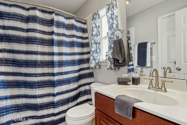 bathroom featuring vanity, curtained shower, and toilet