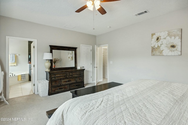 bedroom featuring ensuite bathroom, ceiling fan, light colored carpet, and a textured ceiling