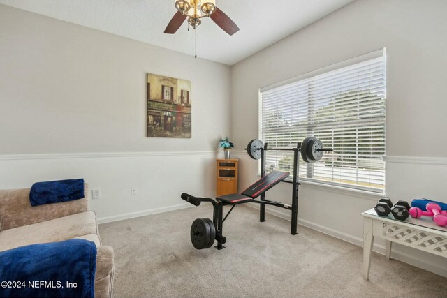 workout area with ceiling fan and light colored carpet