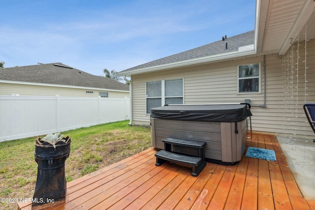 deck featuring a yard and a hot tub