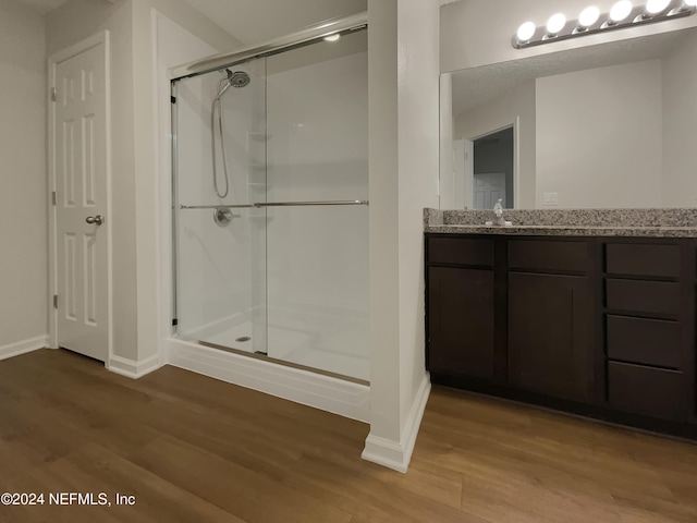 bathroom featuring vanity, hardwood / wood-style flooring, and walk in shower