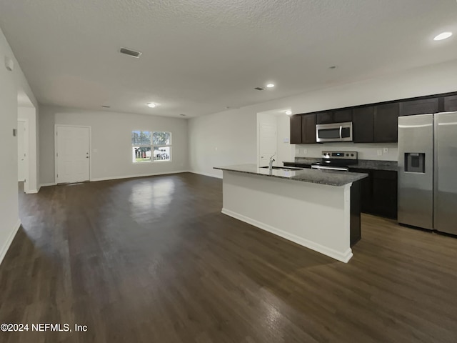 kitchen with a textured ceiling, stainless steel appliances, sink, a center island with sink, and dark hardwood / wood-style floors