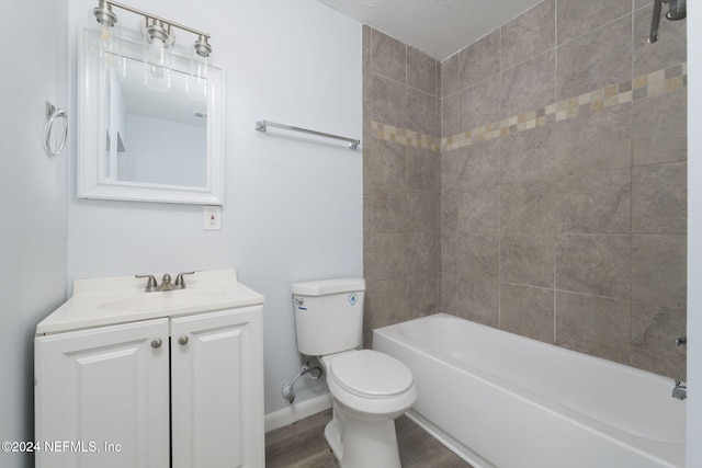 full bathroom with vanity, tiled shower / bath combo, hardwood / wood-style flooring, and toilet