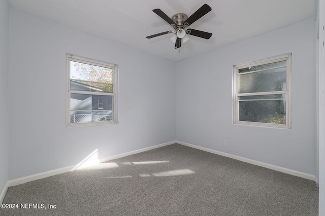 carpeted spare room featuring ceiling fan