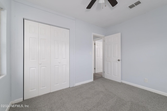 unfurnished bedroom with ceiling fan, carpet floors, and a closet