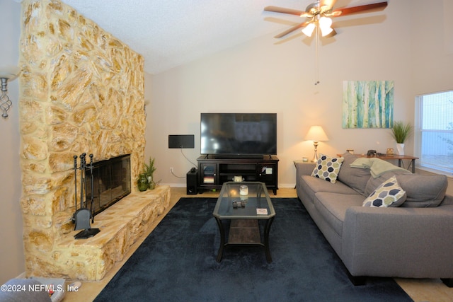 carpeted living room with ceiling fan, a stone fireplace, and high vaulted ceiling