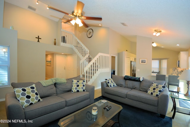 living room featuring ceiling fan, high vaulted ceiling, and a textured ceiling