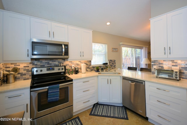 kitchen with sink, white cabinets, and stainless steel appliances