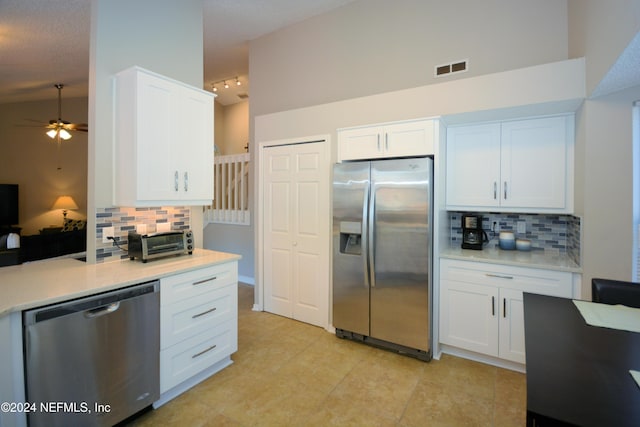 kitchen with tasteful backsplash, white cabinets, and appliances with stainless steel finishes