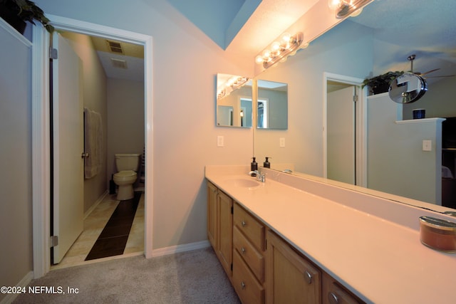 bathroom featuring tile patterned flooring, vanity, and toilet