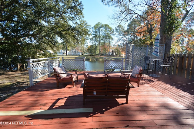 wooden terrace with outdoor lounge area and a water view