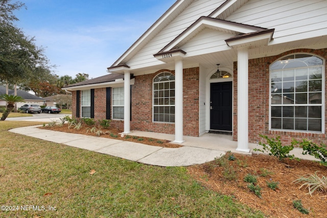 entrance to property with a lawn