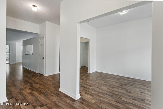 empty room featuring dark wood-type flooring and a textured ceiling