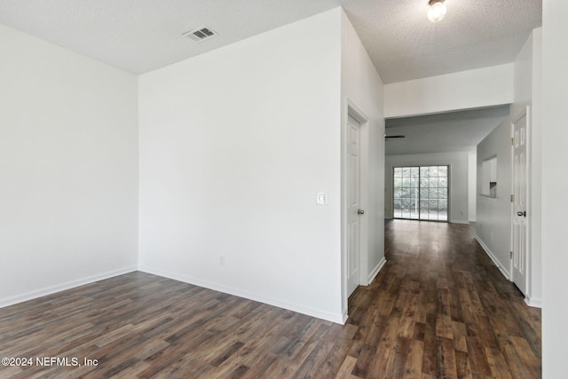 interior space featuring a textured ceiling and dark hardwood / wood-style floors