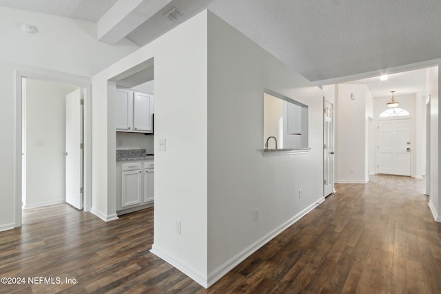 hall featuring a textured ceiling and dark hardwood / wood-style floors