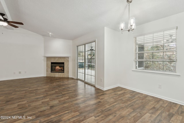 unfurnished living room with a tile fireplace, a wealth of natural light, and dark wood-type flooring