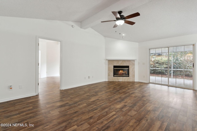 unfurnished living room featuring vaulted ceiling with beams, dark hardwood / wood-style floors, ceiling fan, and a tile fireplace