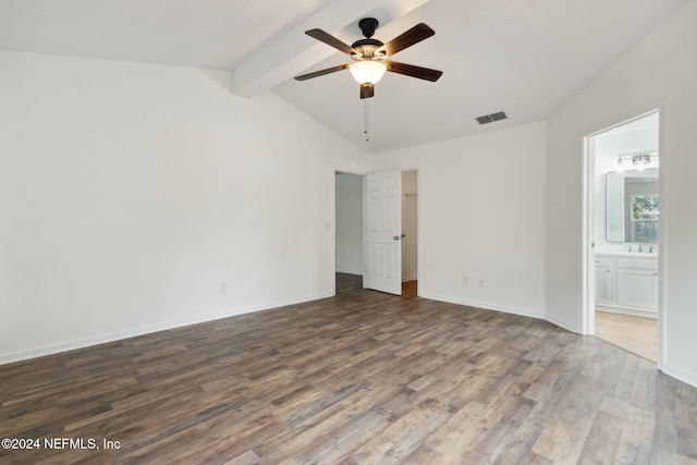 unfurnished bedroom featuring connected bathroom, ceiling fan, dark hardwood / wood-style floors, and vaulted ceiling with beams