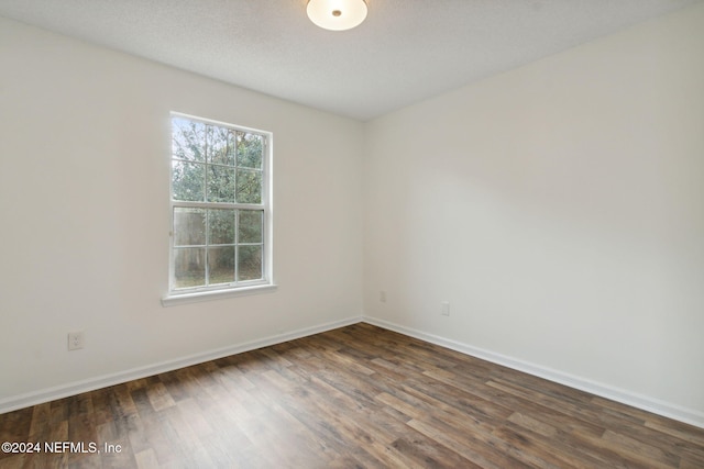 unfurnished room featuring dark hardwood / wood-style floors and a textured ceiling