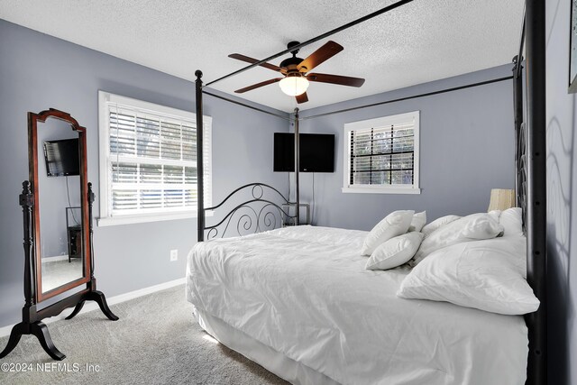 bedroom with carpet flooring, ceiling fan, and a textured ceiling