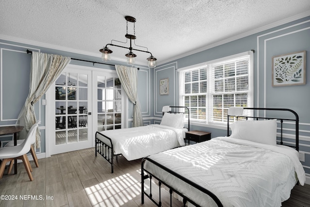 bedroom with hardwood / wood-style flooring, ornamental molding, a textured ceiling, and french doors