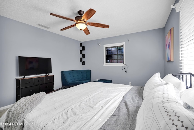 bedroom with a textured ceiling and ceiling fan