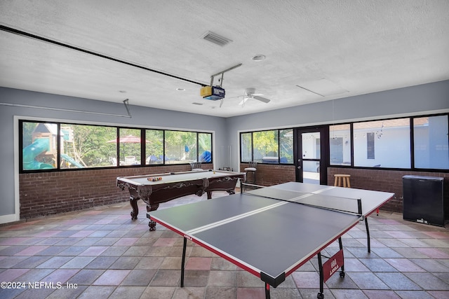 game room with ceiling fan, brick wall, a textured ceiling, and pool table