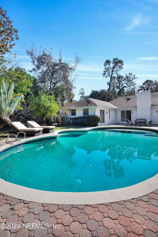 view of pool with a diving board