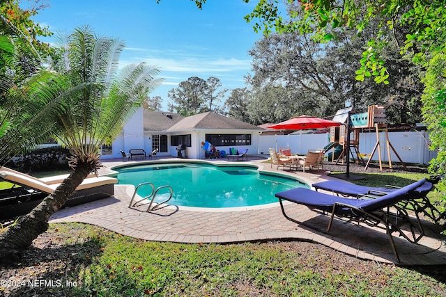 view of pool featuring a playground and a patio