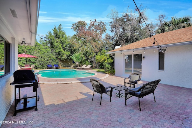 view of swimming pool featuring a patio and a grill