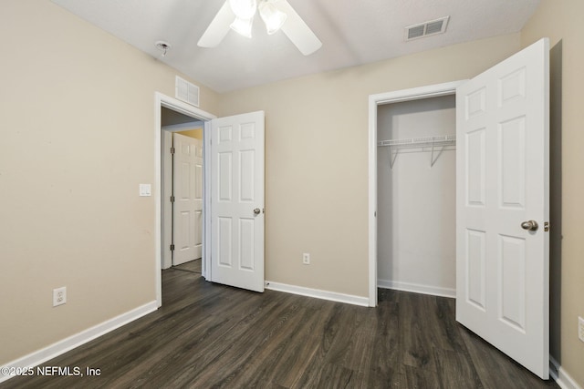 unfurnished bedroom featuring dark hardwood / wood-style floors, ceiling fan, and a closet