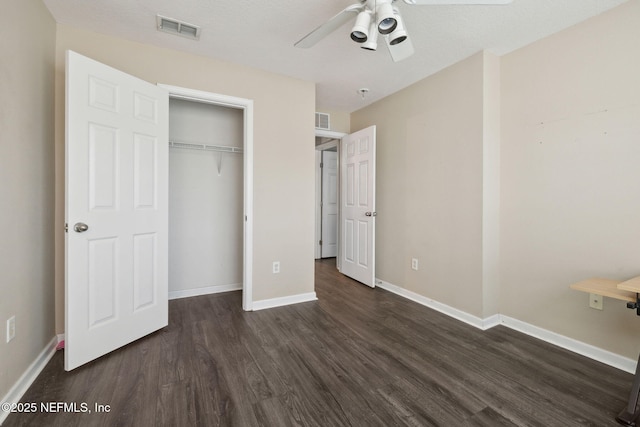 unfurnished bedroom featuring ceiling fan, dark hardwood / wood-style flooring, and a closet