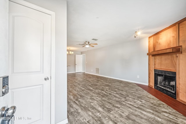 unfurnished living room featuring dark hardwood / wood-style flooring, ceiling fan, and a fireplace